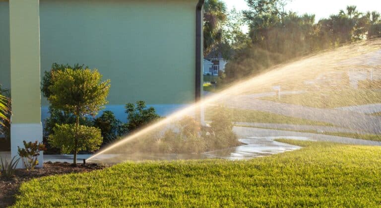 Sprinkler watering a Charlotte lawn, illustrating DIY vs professional irrigation winterization and the need to protect irrigation systems before frost.